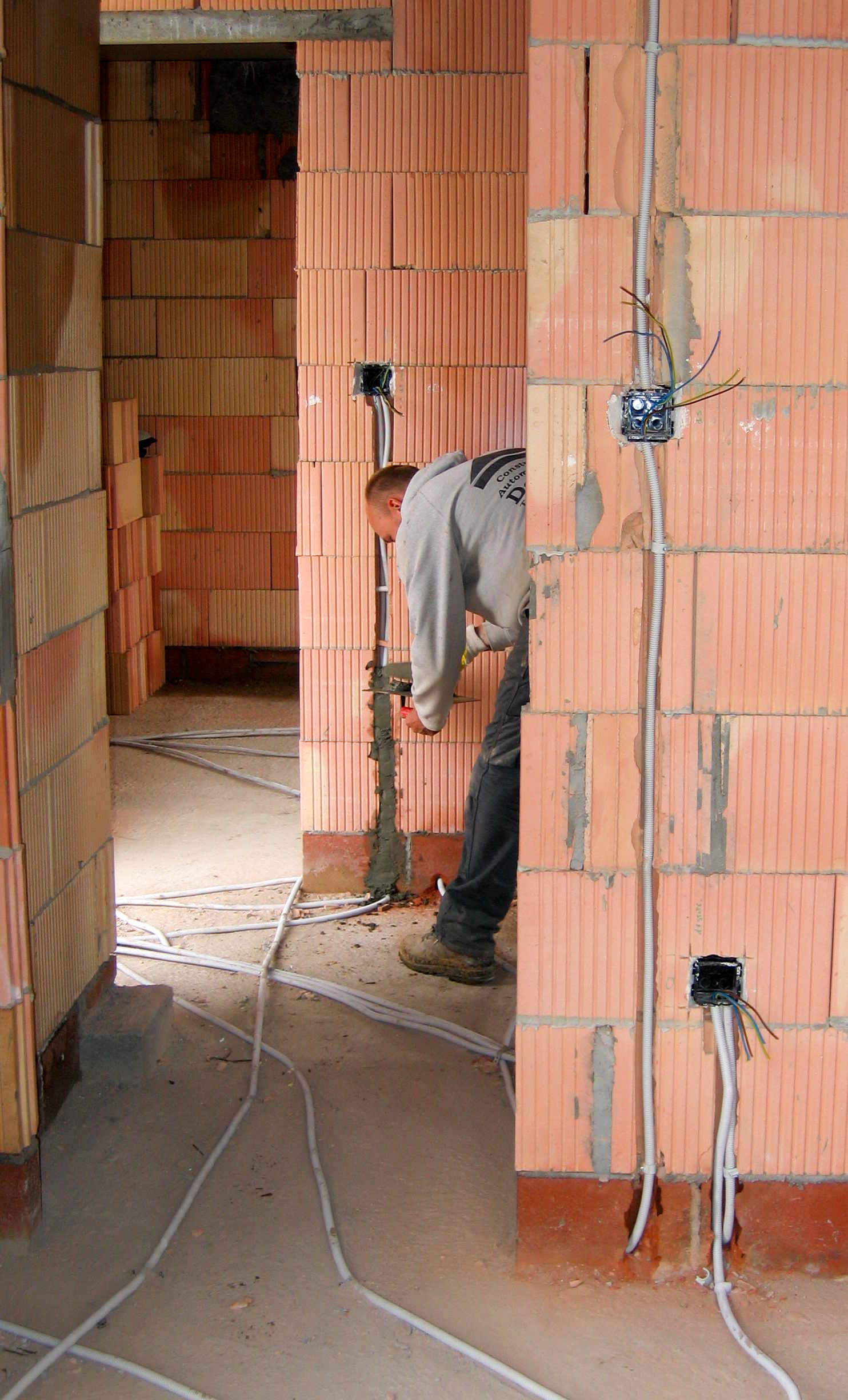 Electrical wiring being routed through masonry walls. KVDP, via Wikimedia Commons. Public domain.